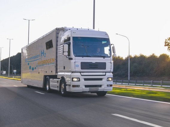 Wasserstoff-LKW auf einer Straße mit Landschaft im Hintergrund