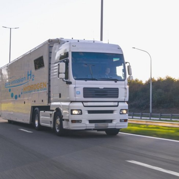 Wasserstoff-LKW auf einer Straße mit Landschaft im Hintergrund