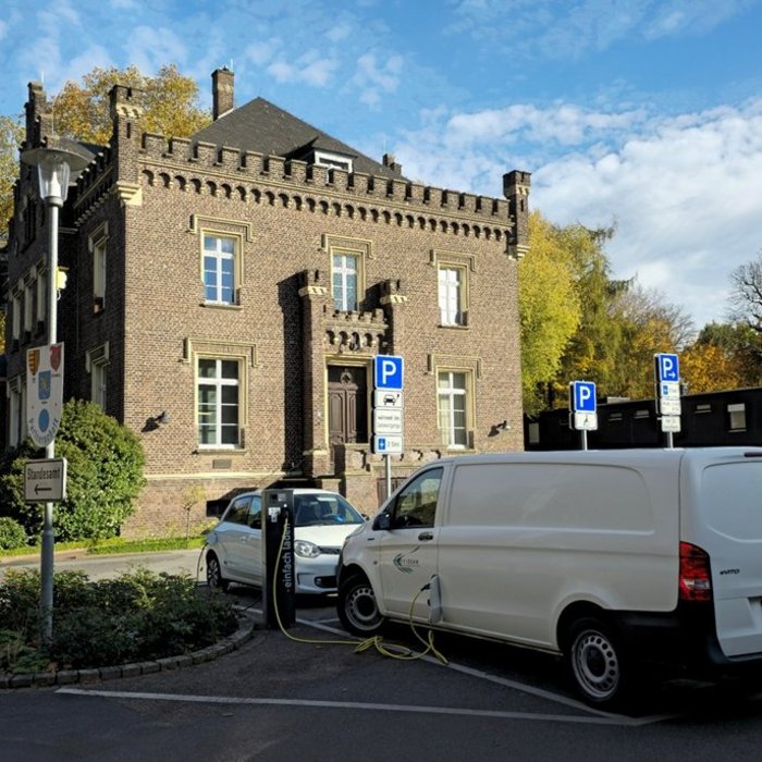 Zwei ladende Pkws vor einem Historischen Gebäude