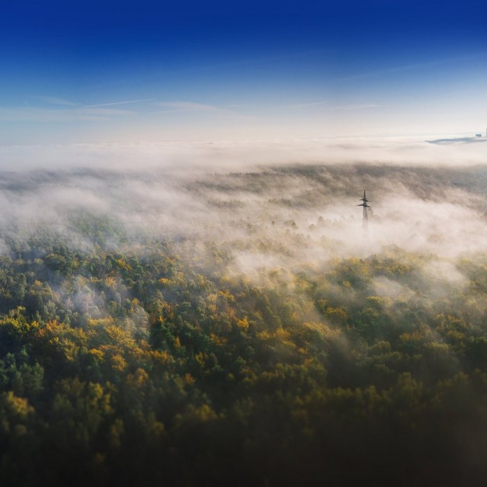 weite Landschaft, die von einem dichten Nebel oder Dunst bedeckt ist.
