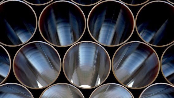Nahaufnahme von mehreren großen Metallrohren, die horizontal gestapelt sind